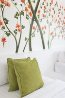 Una habitación con un sofá blanco y almohadones verdes con textura.