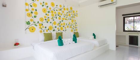 Un dormitorio moderno con una cama grande, paredes blancas y un mural floral.