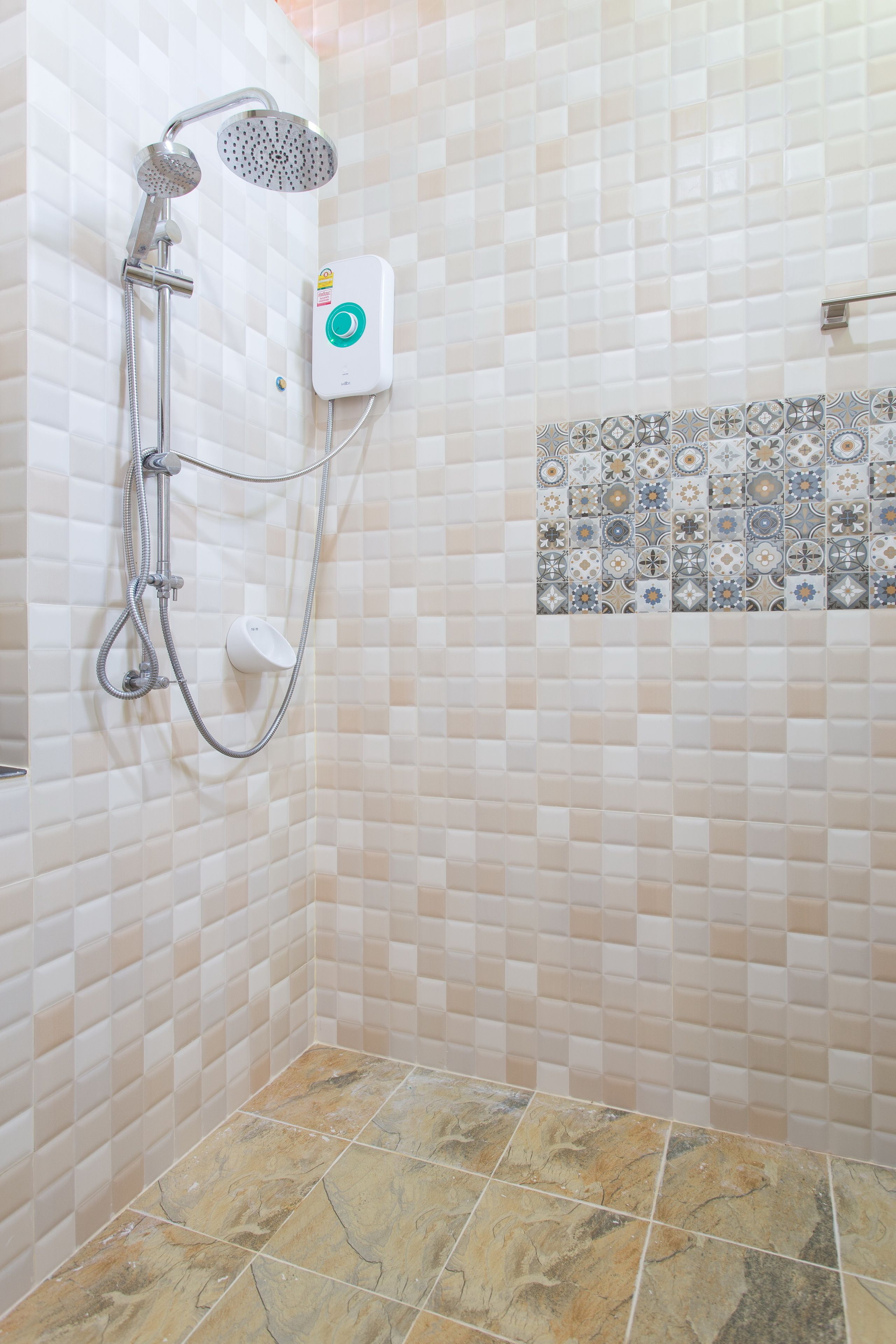 A shower with a handheld showerhead and a wall-mounted control panel.