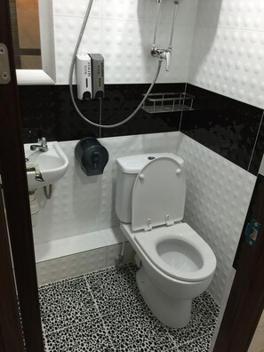 A bathroom with a toilet, bidet, and sink. - Skyview Hostel (Kowloon)