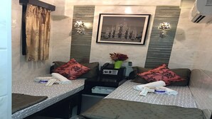 A hotel room with two beds, a small table, a chair, a telephone, and a framed picture on the wall. - Skyview Hostel (Kowloon)