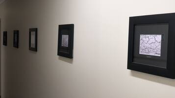 Una pared galería con obras de arte enmarcadas.