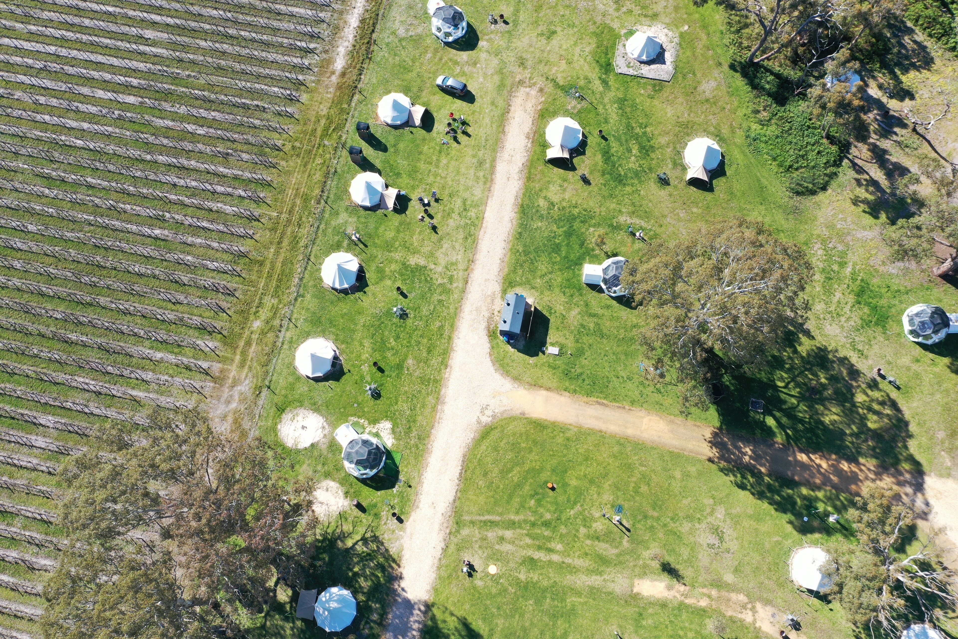 An aerial view of a campsite with multiple dome-shaped tents arranged in rows.