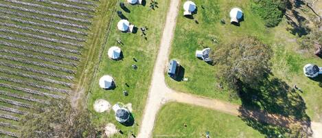 An aerial view of a campsite with multiple dome-shaped tents arranged in rows.