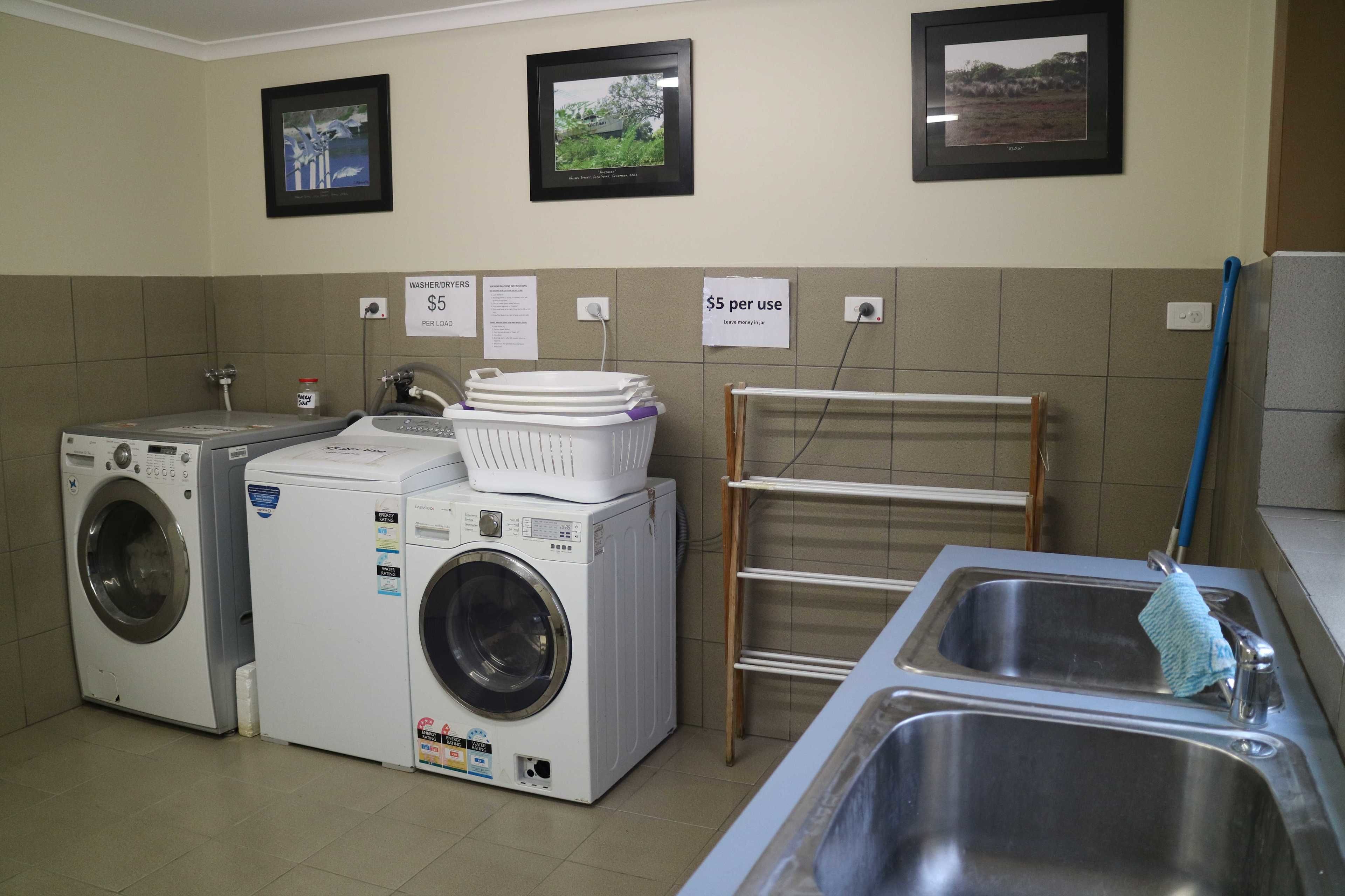 Un cuarto de lavandería con dos lavadoras, un tendedero y un lavabo.