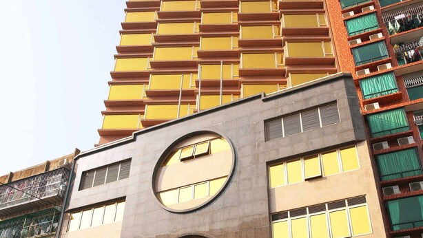 A hotel with a modern facade, featuring a prominent circular window design and balconies. - Grand Harbour Hotel (Macau)