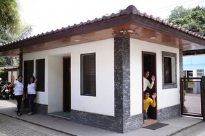 A small, single-story building with a tiled roof and a stone base. There are two visible doors and windows.