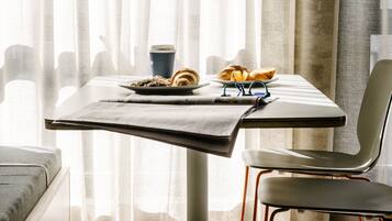 A dining area with a table, chairs, and a breakfast setting.