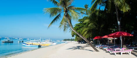 Plage, sable blanc, chaises longues, parasols