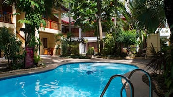 Alberca al aire libre y camastros