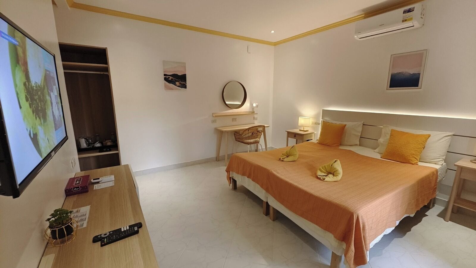 Een hotelkamer met een bed, nachtkastjes, een bureau, een stoel, een televisie en een kledingkast.