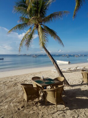 Aan het strand, wit zand, ligstoelen aan het strand, parasols