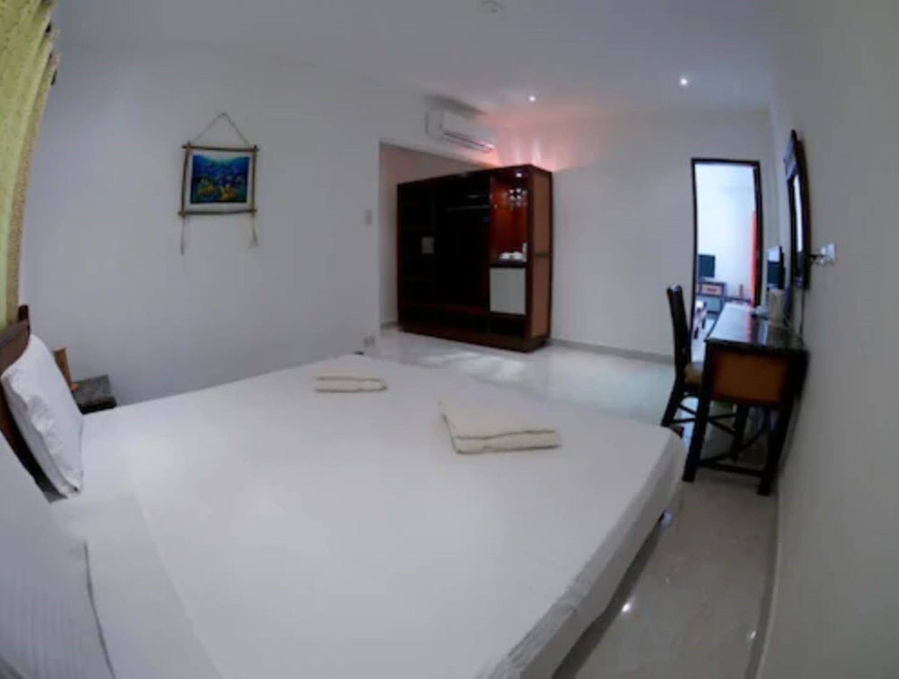 A bedroom with a bed, a desk, a chair, and a wardrobe.