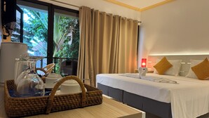 A hotel room with a bed, bedside table, and a window with curtains. - Alona Vida Beach Resort (Panglao)