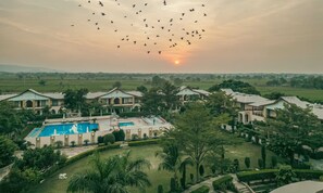 A resort with multiple buildings, a swimming pool, and a large open lawn. - Abhyaran Resort Ranthambore (Sawai Madhopur)