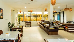 Un comedor moderno con una isla central, mobiliario de madera e iluminación colgante.