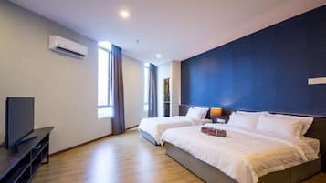A hotel room with two beds, a flat-screen TV, an air conditioning unit, and a large window with curtains.