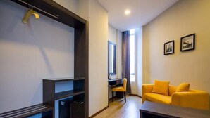 A modern living room with a sofa, a desk, and a wardrobe. - OMG Hotel (Simpang Ampat)