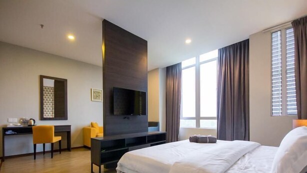 A hotel room with a large bed, a desk, a flat-screen TV, and a window with curtains. - OMG Hotel (Simpang Ampat)