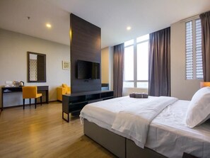A hotel room with a large bed, a desk, a flat-screen TV, and a window with curtains. - OMG Hotel (Simpang Ampat)