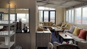 A room with a high ceiling, large windows, a kitchenette, and seating area with a view. - Istanbul Paris Hotel & Hostel (Istanbul)
