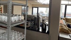 A kitchen area with shelves holding glassware, a coffee machine, and a kettle. - Istanbul Paris Hotel & Hostel (Istanbul)