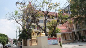 A multi-story building with a traditional architectural style, featuring balconies and a red-tiled roof.