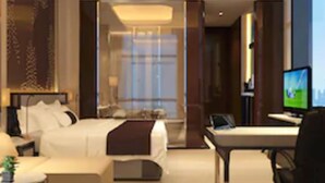 A modern hotel room with a bed, desk, chair, and a television. - Wuhan You Yi International Hotel (Wuhan)