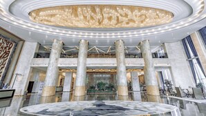 A spacious lobby with a large, circular marble floor, multiple columns, and a grand chandelier. - Wuhan You Yi International Hotel (Wuhan)