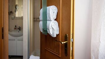 A wooden door with a towel rack holding two white towels.