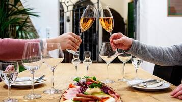 A dining table with a variety of food items and multiple wine glasses.