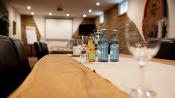 A conference table with water bottles, glasses, and a projector screen in a meeting room.