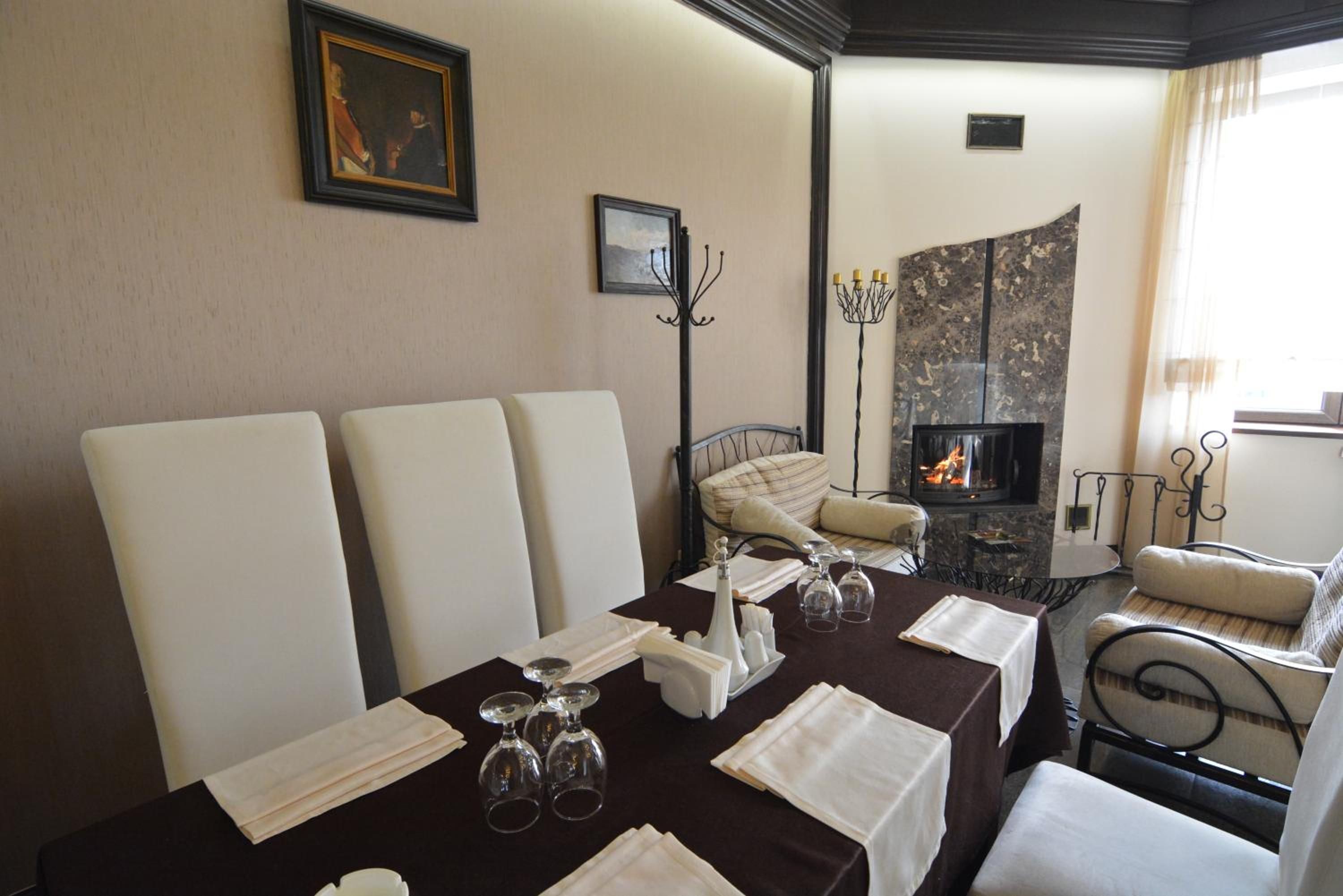 Un comedor con una mesa dispuesta para cuatro personas, una chimenea y una zona de estar acogedora.