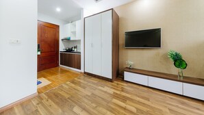 Una cocina moderna con armarios de madera, horno empotrado y microondas.