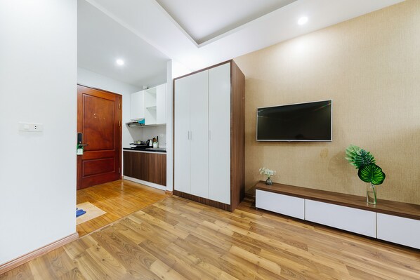 A modern kitchen with wooden cabinets, a built-in oven, and a microwave. - Hana 1 Apartment & Hotel Bac Ninh (Vo Cuong)