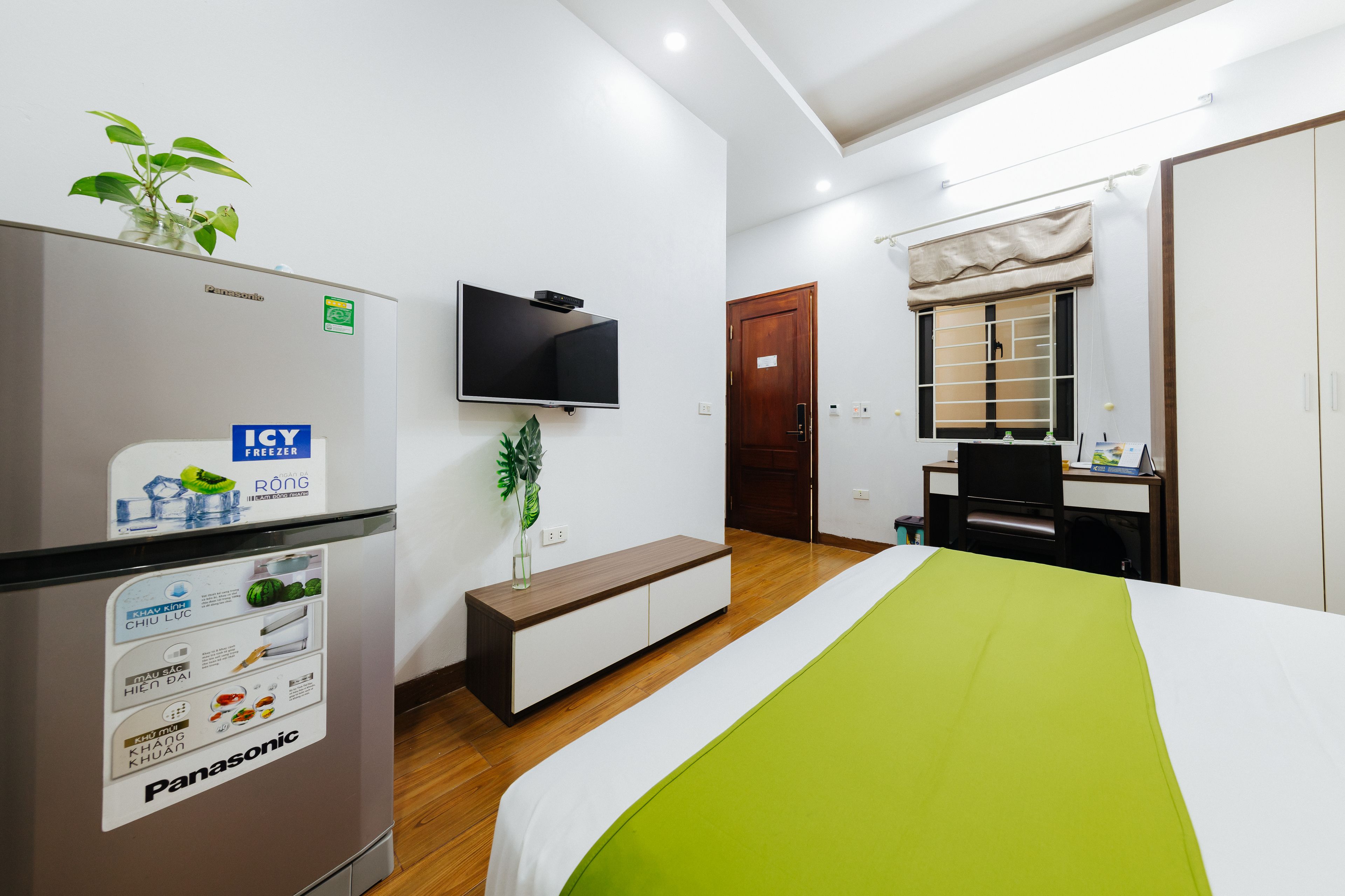 Une chambre d’hôtel équipée d’un lit, d’une télévision, d’un minibar, d’un bureau et d’une armoire.
