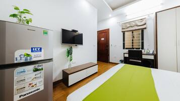 Une chambre d’hôtel équipée d’un lit, d’une télévision, d’un minibar, d’un bureau et d’une armoire.