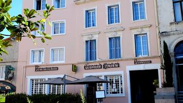 Un edificio rosa con un cartel que dice 'Grand Hotel' y 'Restaurante'.