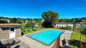 Una piscina rectangular con cubierta de madera y cerca metálica.