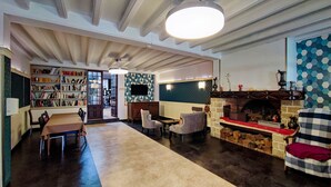 Una sala de estar amplia con chimenea, zona de comedor y biblioteca.