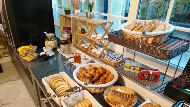 Un bufé de desayuno con diversos pasteles, pan y fruta.