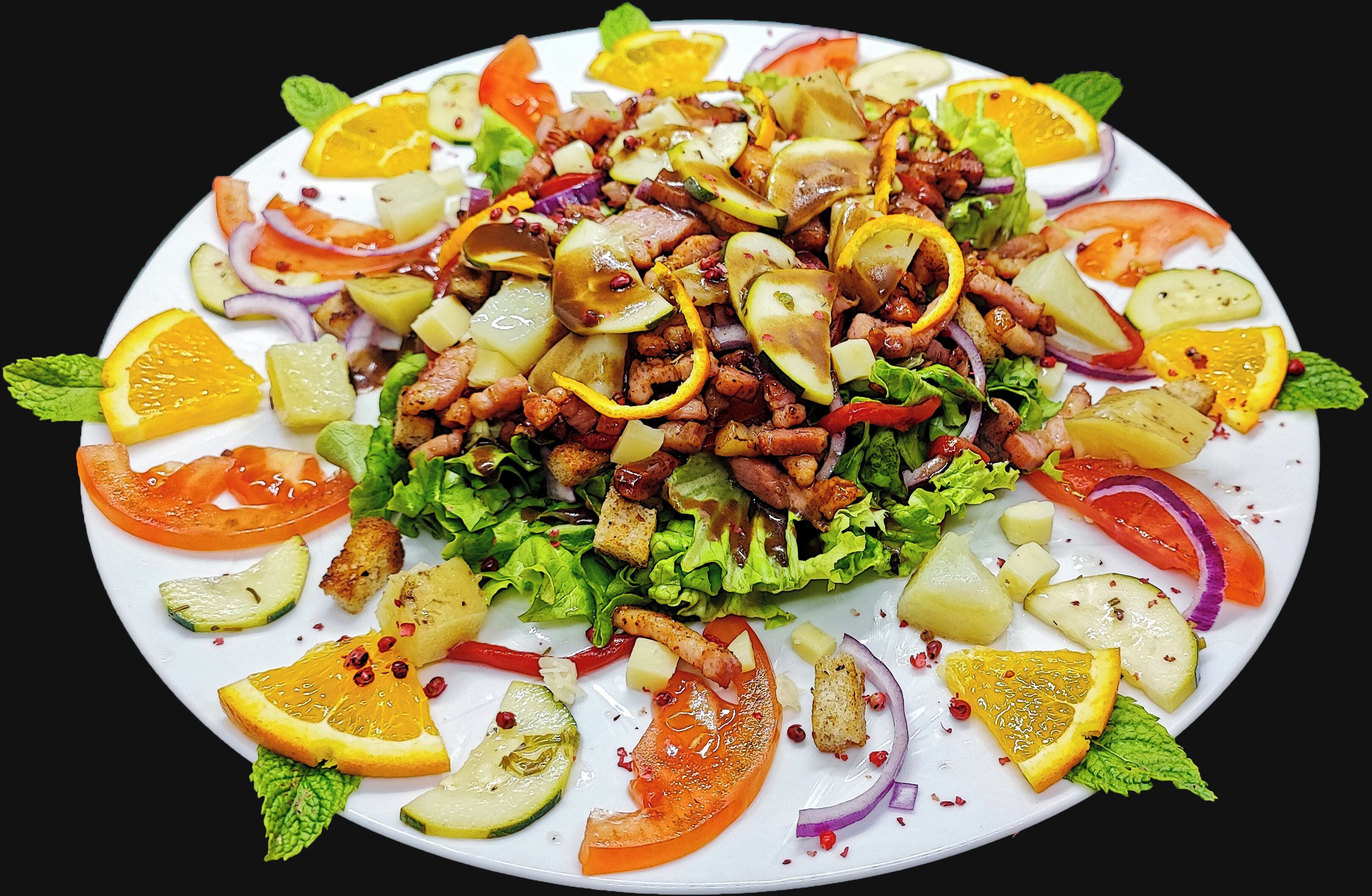 Une salade composée de divers fruits et légumes, présentée dans une assiette.