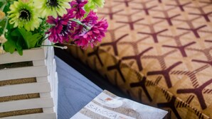 A brochure for Sanya Resort, a business card, and a bouquet of flowers on a table.