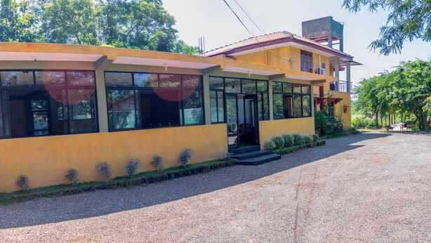 A yellow building with large windows and a covered entrance.