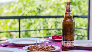 A table with plates of food and a bottle of beer.