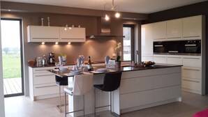 Una cocina moderna con una isla central, taburetes de bar y un área de comedor.