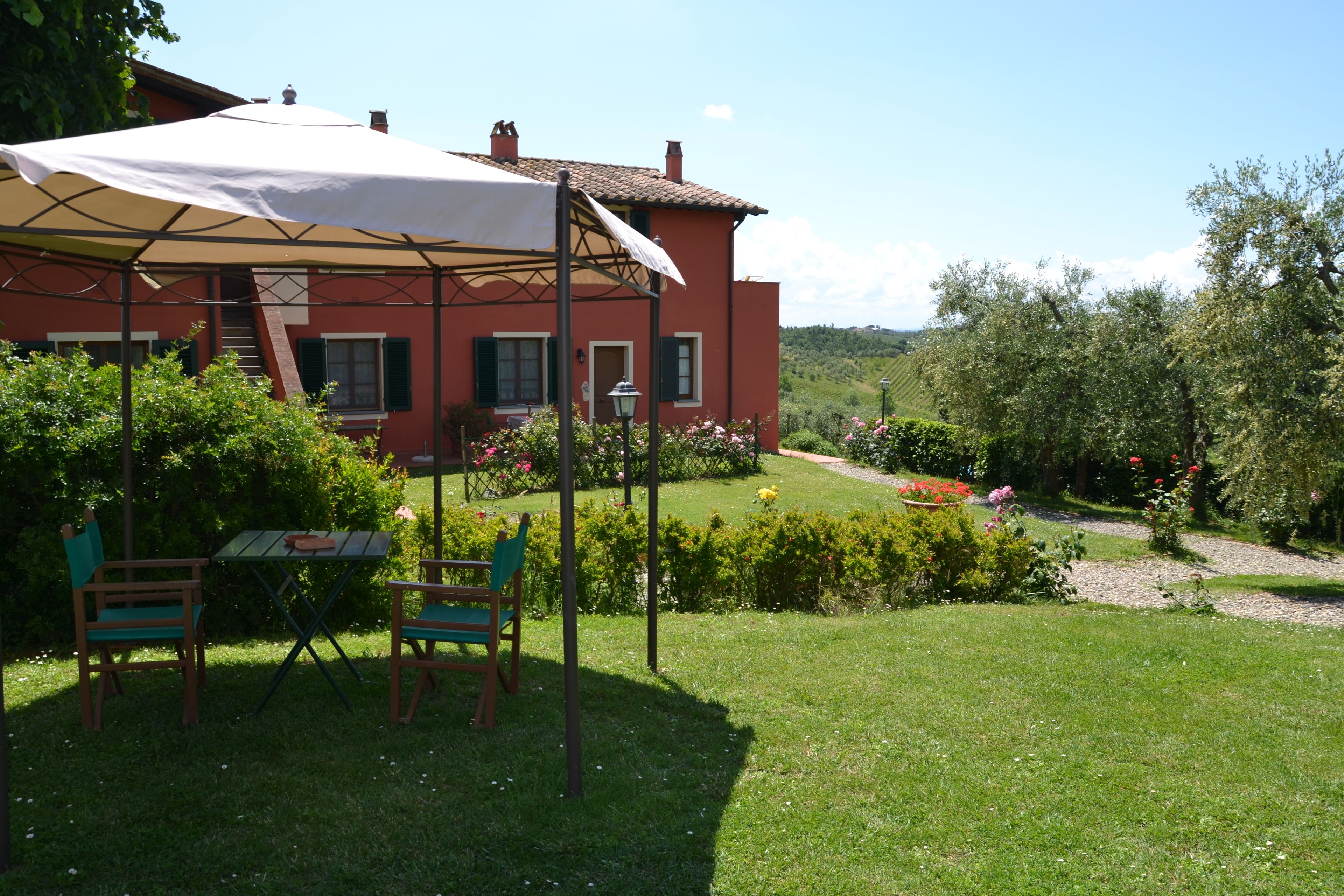 Una casa roja con un porche cubierto, una mesa y dos sillas.