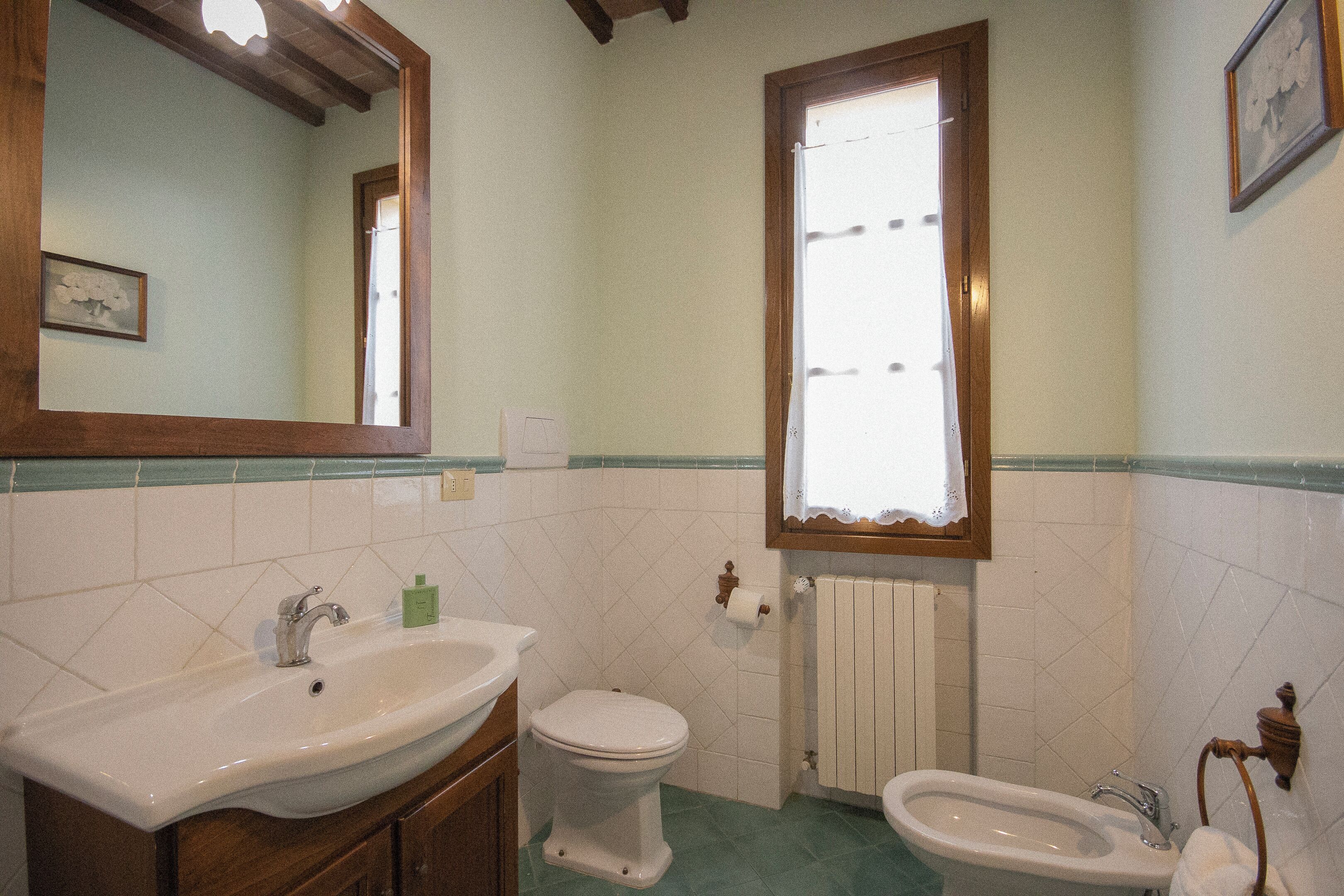 A bathroom with a sink, toilet, and bidet.