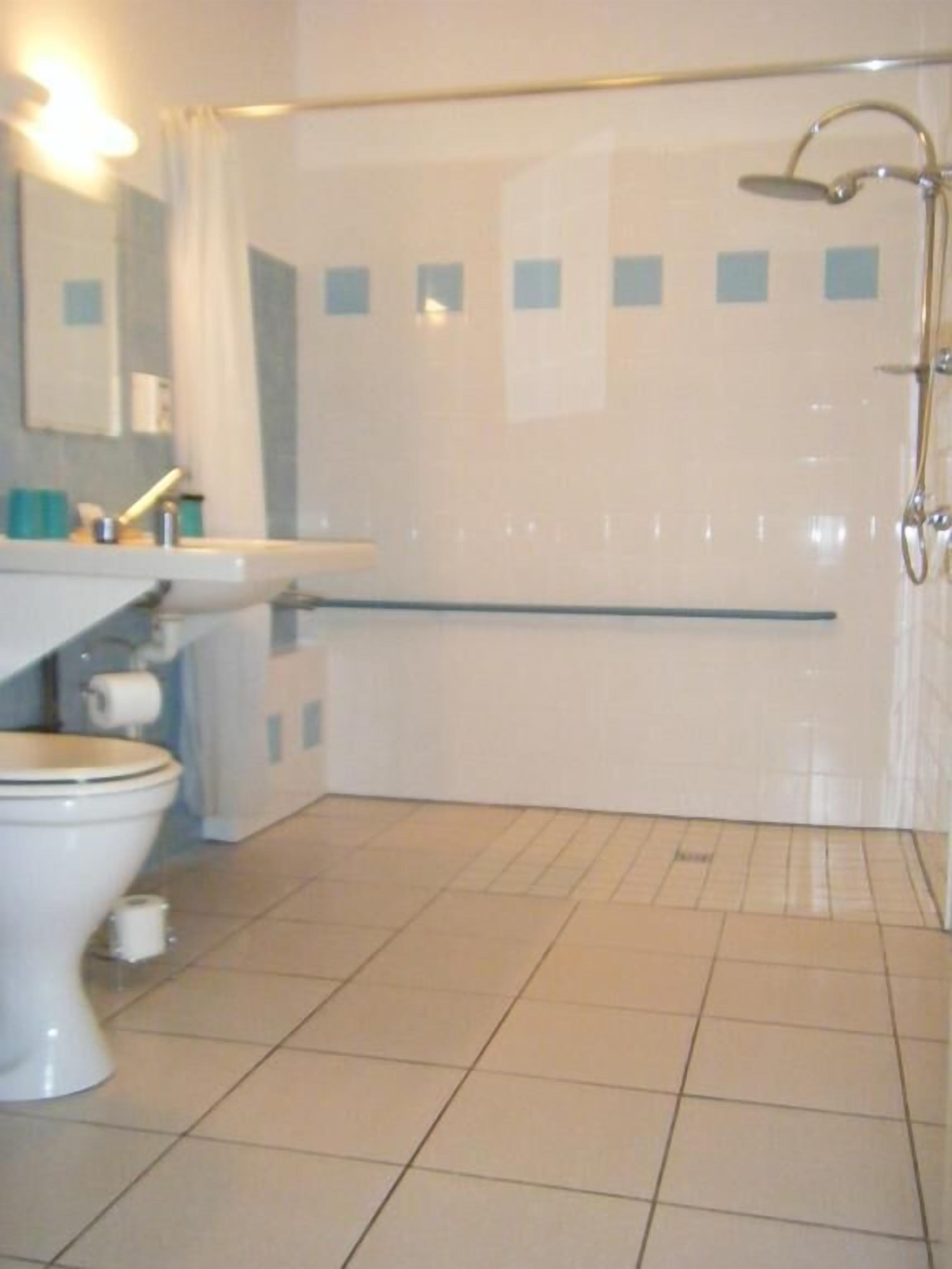A bathroom with a toilet, sink, and shower.