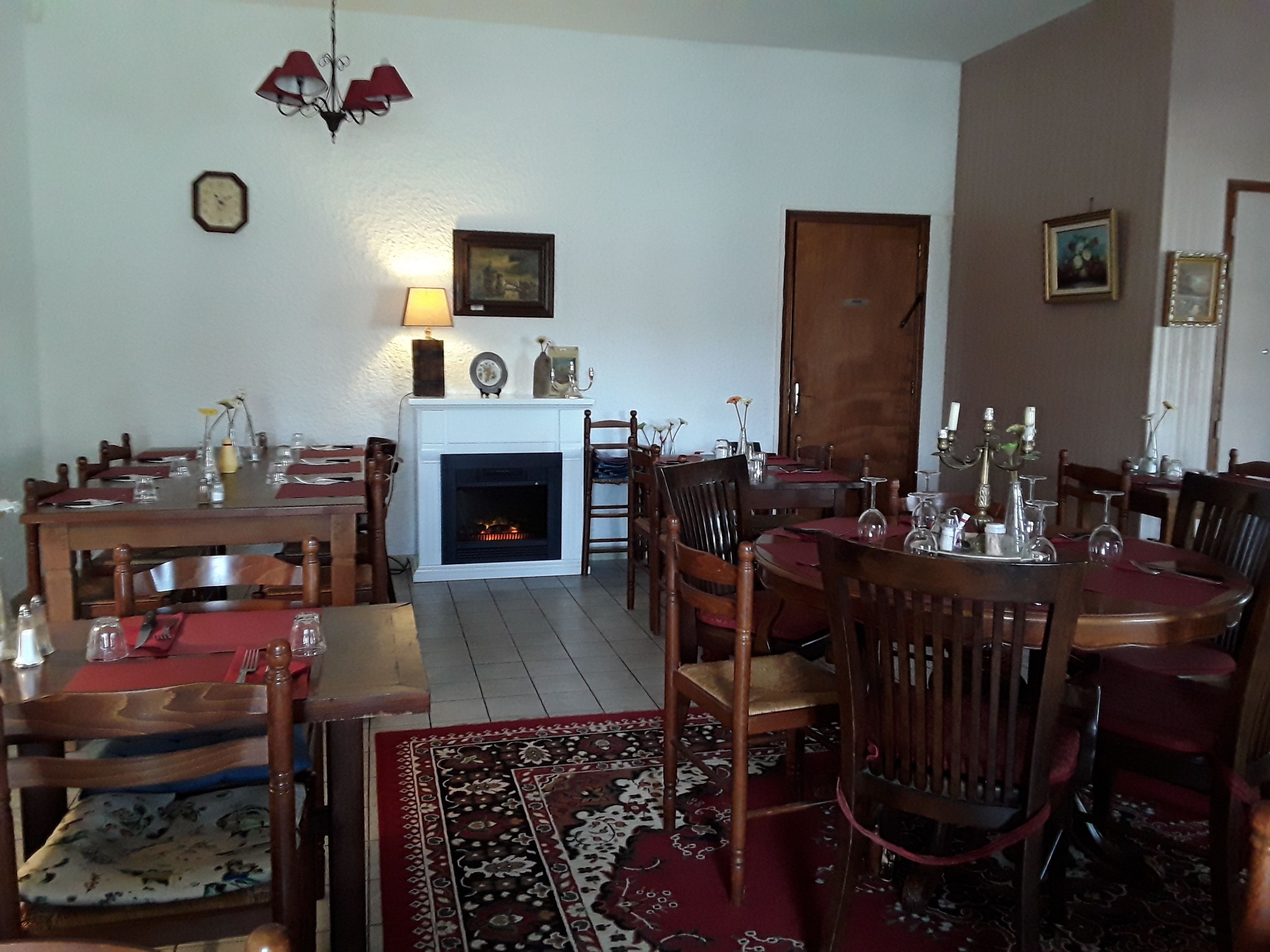 Comedor con chimenea, muebles de madera y alfombra estampada.